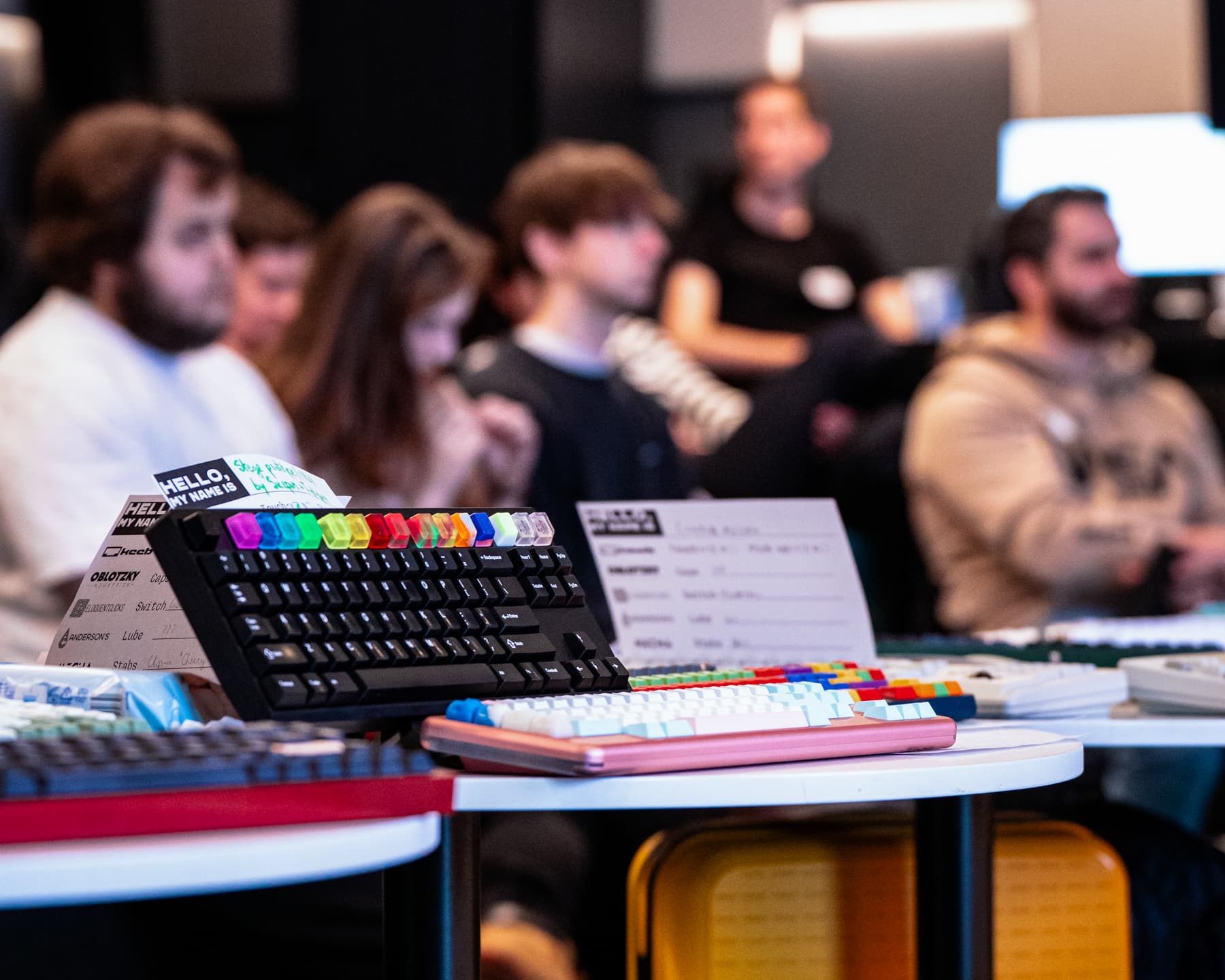 Upclose shot of keyboards, people in the background.