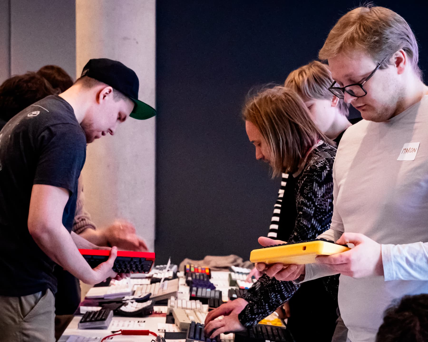 People inspecting and holding keyboards.